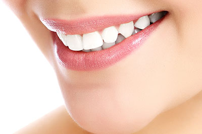 The image shows a close-up of a person s face with a focus on their mouth, featuring a bright smile and teeth.